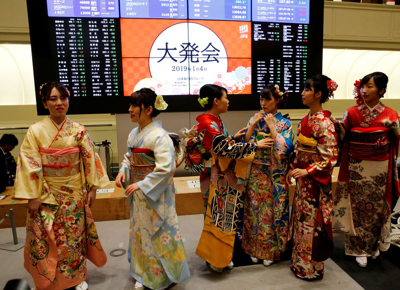 © Reuters. Women, dressed in ceremonial kimonos, chat in front of an electronic board showing stock prices after the New Year opening ceremony at the Tokyo Stock Exchange (TSE), held to wish for the success of Japan's stock market, in Tokyo