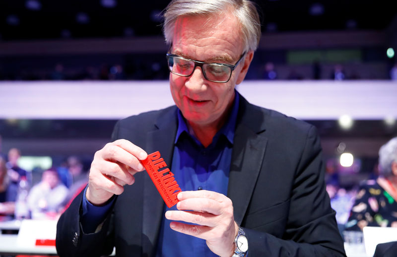 © Reuters. Dietmar Bartsch holds the slogan of a three day party congress of Germany's left-wing party Die Linke "The Left - fights for the Human Rights" in Bonn
