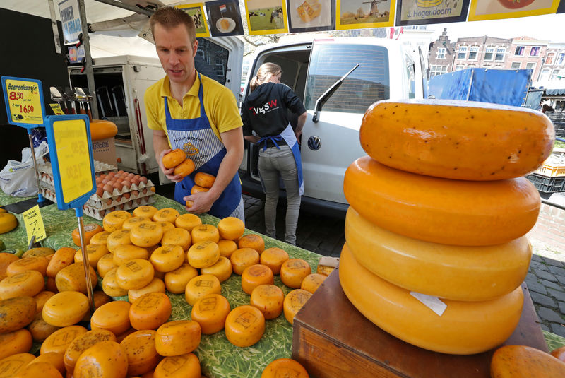 © Reuters. Seller arranges product on a table at the cheese market in Gouda