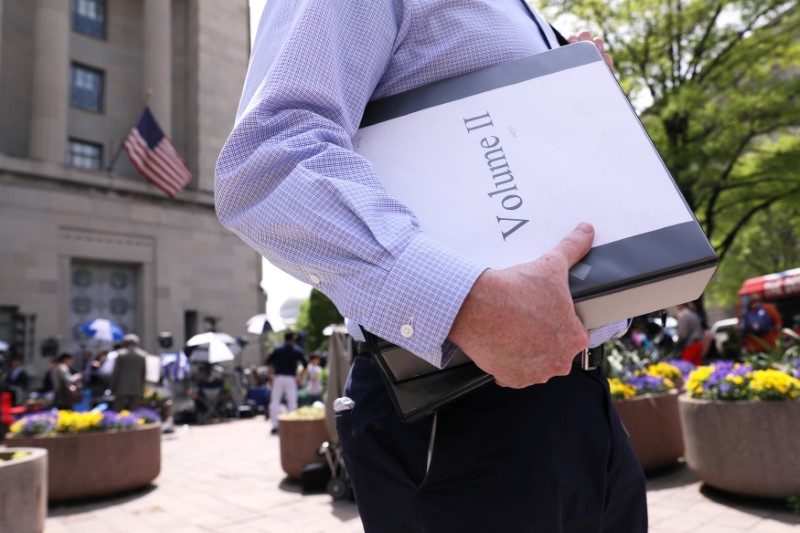 © Reuters. Foto de archivo. Un reportero lleva una copia oficial del reporte del fiscal especial Robert Mueller sobre la interferencia rusa en la elección presidencial de 2016, a las afueras del Departamento de Justicia, Washington, EEUU.