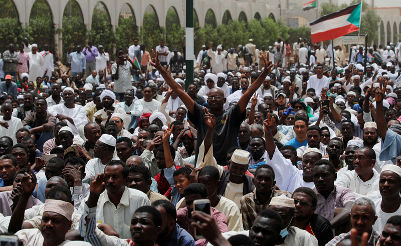 © Reuters. Protesters shout slogans and make victory signs after Friday prayers in front of the Defence Ministry in Khartoum