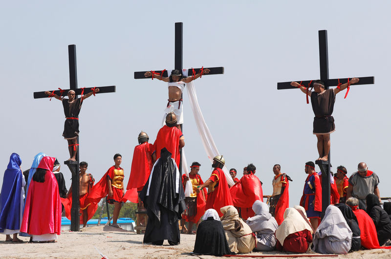 © Reuters. فلبينيون يحاكون صلب المسيح بمناسبة عيد القيامة