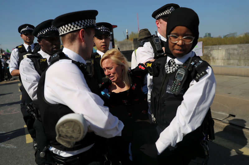 © Reuters. Foto del sábado de agentes de la policía deteniendo a una manifestante contra el cambio climático en el Puente Waterloo de Londres