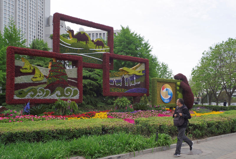 © Reuters. Man walks past a flower installation set up for the upcoming Belt and Road Forum in front of the Chinese Foreign Ministry in Beijing