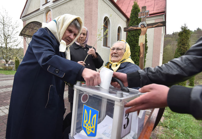 © Reuters. Foto del domingo de un grupo de ucranianos votando en una urna móvil en Maidan en la segunda vuelta de la elección presidencial de Ucrania