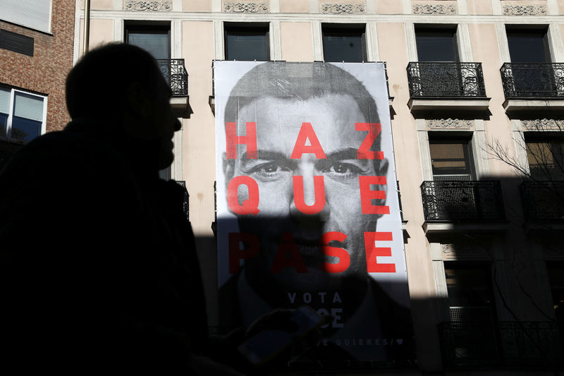 © Reuters. A man walks past an electoral poster of Spain's Socialist (PSOE) leader and current PM Sanchez outside the PSOE headquarters in Madrid