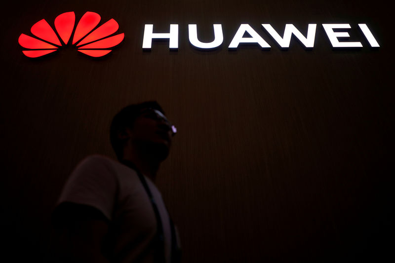 © Reuters. FILE PHOTO: A man walks past a sign board or Huawei at CES (Consumer Electronics Show) Asia 2018 in Shanghai