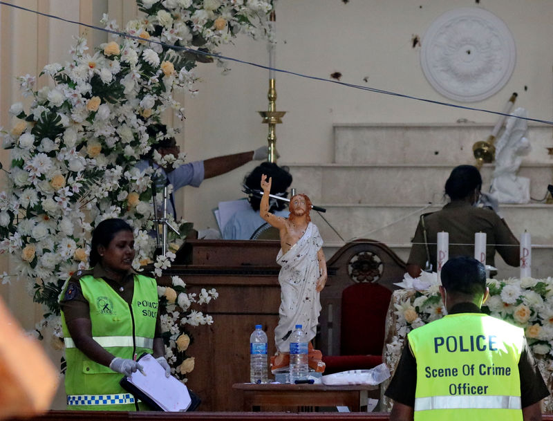 © Reuters. Agentes de policía en la iglesia católica de San Sebastián, después de que estallaron bombas en iglesias y hoteles de lujo el domingo de Pascua, en Negambo