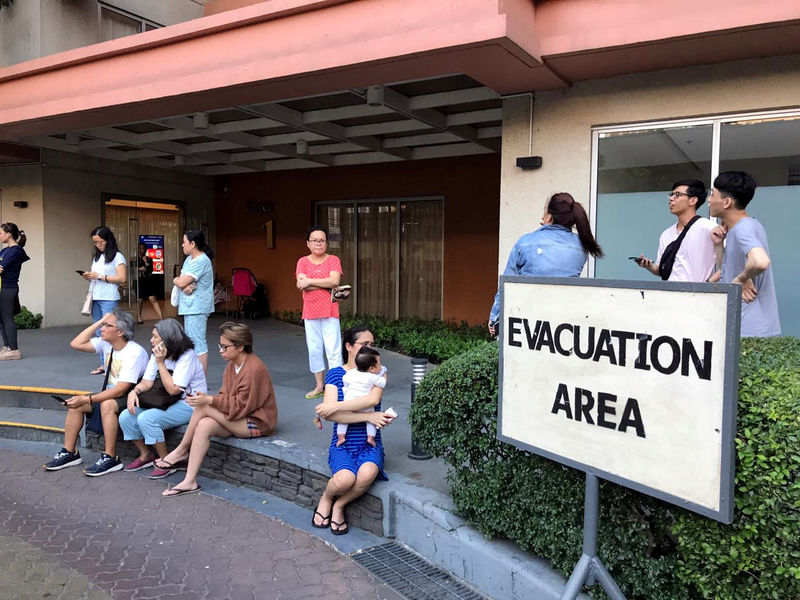 © Reuters. Moradores do lado de fora de prédio esvaziado devido a terremoto em Makati, nas Filipinas