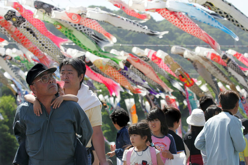 © Reuters. FILE PHOTO : Holidaymakers view thousands of carp streamaers in Sagamihara, Japan.