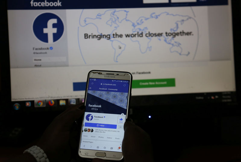 © Reuters. An illustration photo shows the Facebook page displayed on a mobile phone internet browser held in front of a computer screen at a cyber-cafe in downtown Nairobi