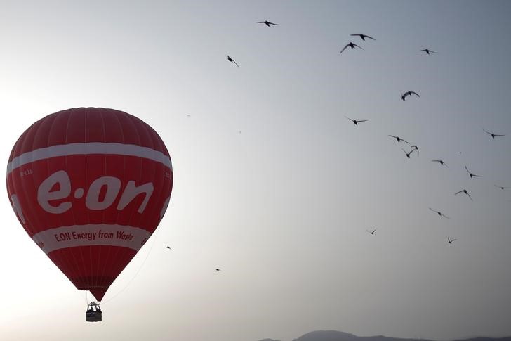 © Reuters. A hot air balloon with the logo of German energy giant E.ON flies at dawn in Ronda