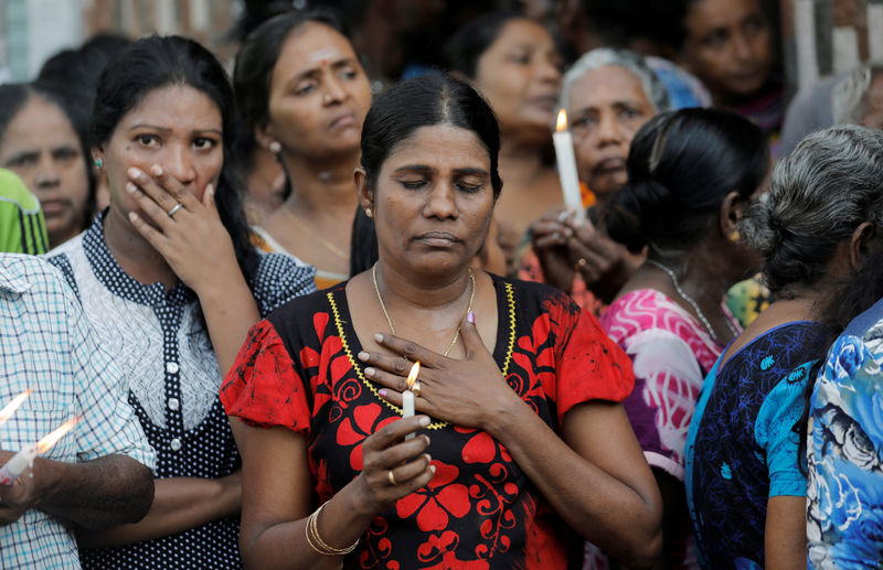 © Reuters. People react as silence is observed as a tribute to victims two days after a string of suicide bomb attacks on churches and luxury hotels across the island on Easter Sunday, during a memorial service in Colombo