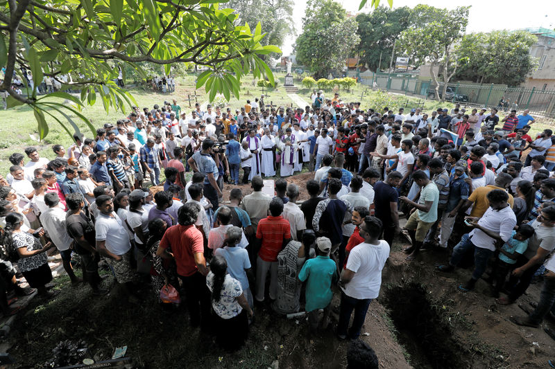 © Reuters. Gente asiste a un entierro masivo de víctimas en Colombo