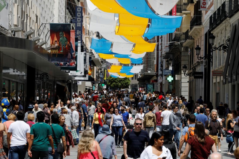 © Reuters. People walk through one of the main pedestrian shopping areas, Preciados street, in central Madrid