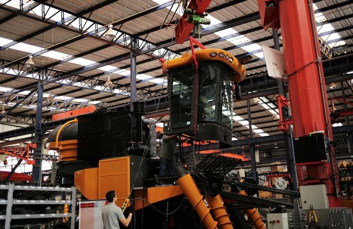 © Reuters. Employees work at a harvest machine assembly line at the AGCO Agricultural Machinery Plant in Ribeirao Preto
