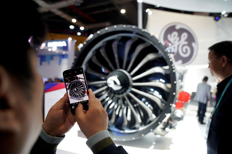 © Reuters. FILE PHOTO: A man takes a picture of a General Electric (GE) engine during the China International Import Expo (CIIE), at the National Exhibition and Convention Center in Shanghai