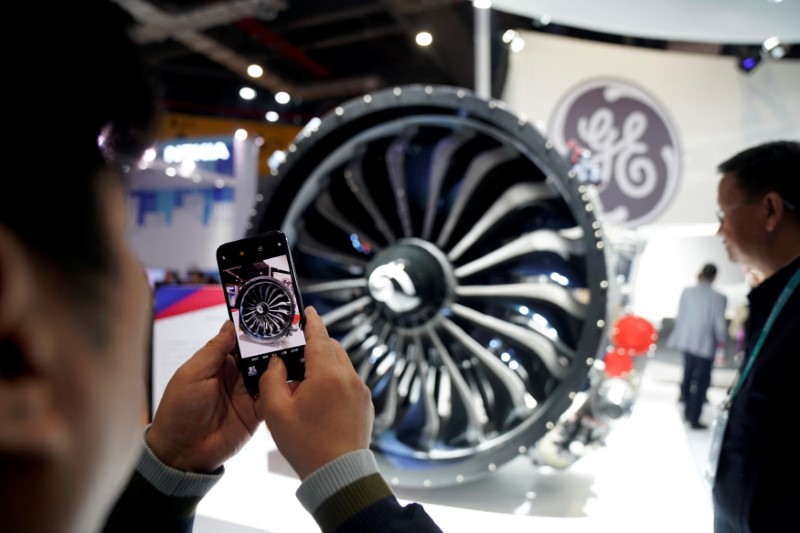 © Reuters. FILE PHOTO: A man takes a picture of a General Electric (GE) engine during the China International Import Expo (CIIE), at the National Exhibition and Convention Center in Shanghai