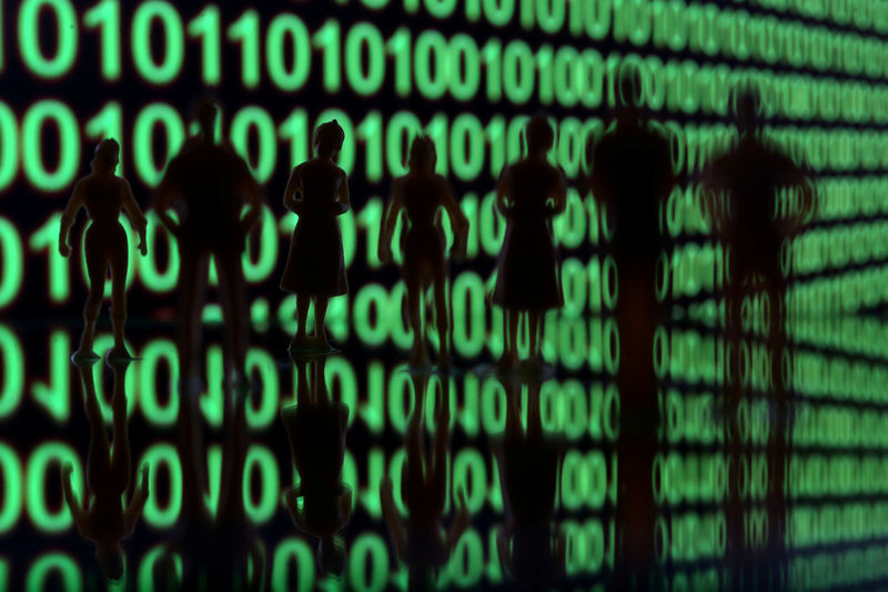 © Reuters. FILE PHOTO: Small toy figures are seen in front of a binary code in this illustration picture