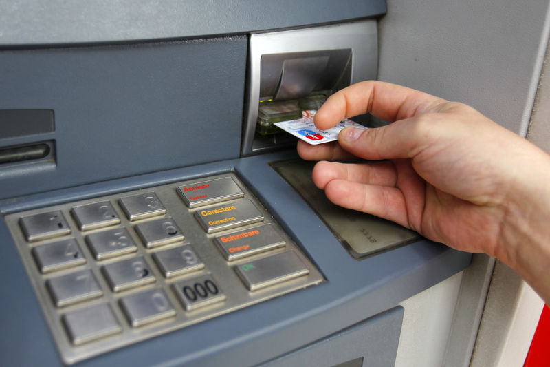 © Reuters. FILE PHOTO - Man uses traditional ATM in Bucharest