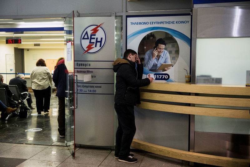 © Reuters. FILE PHOTO: A man waits at a Public Power Corporation (PPC) branch to enter a repayment scheme for their debts in Athens