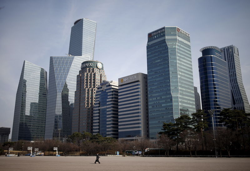 © Reuters. A man walks in a park at a business district in Seoul