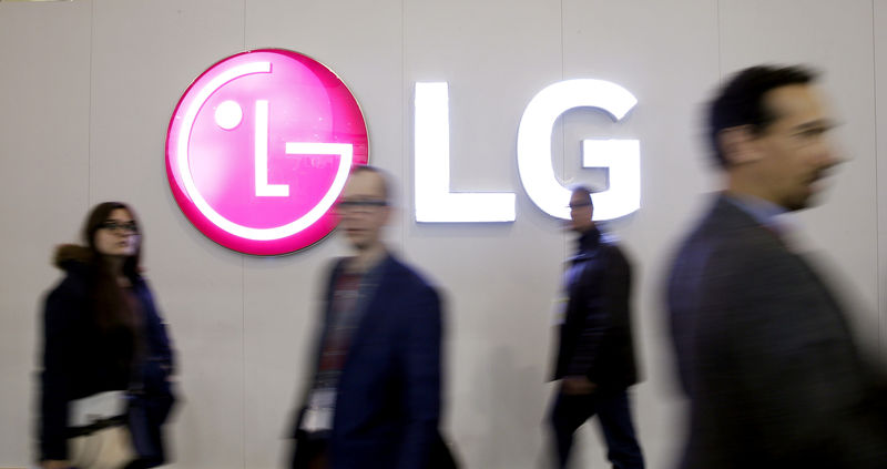 © Reuters. FILE PHOTO: People walk past an LG Electronics logo during the Mobile World Congress in Barcelona