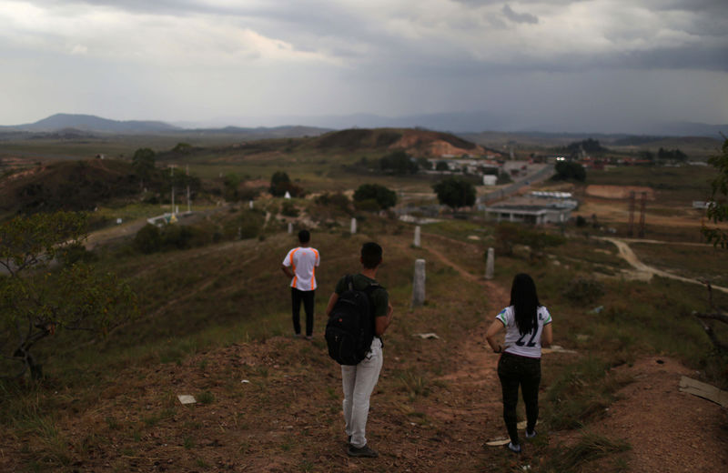 © Reuters. Desertores de la Guarda Nacional venezolana, que no quieren ser identificados, miran hacia la frontera con Venezuela desde la localidad de Pacaraima