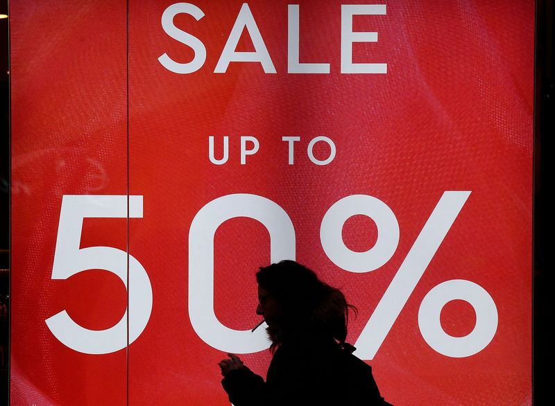 © Reuters. FILE PHOTO - A person walks past a sale sign on Oxford Street in London