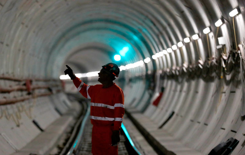 © Reuters. FILE PHOTO: A worker stands on the railway track in a tunnel of the Crossrail project in east London
