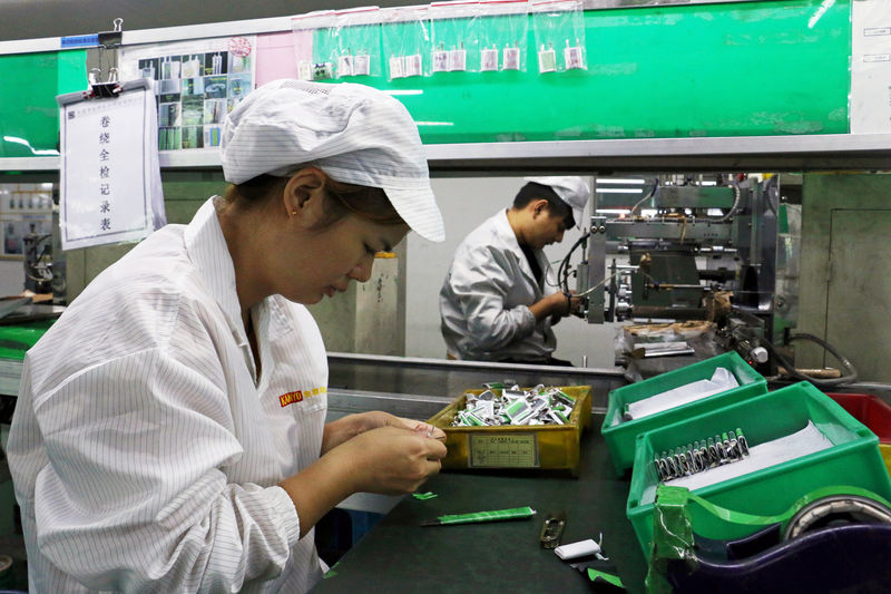 © Reuters. FILE PHOTO:    Employees work at a production line of lithium ion batteries inside a factory in Dongguan