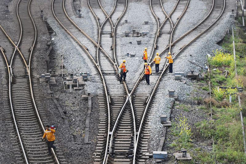 © Reuters. FILE PHOTO: Workers inspect railway tracks, which serve as a part of the Belt and Road freight rail route linking Chongqing to Duisburg, at the Dazhou railway station