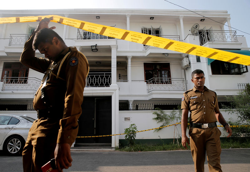 © Reuters. FILE PHOTO: Police keep watch outside the family home of a bomber suspect where an explosion occurred during a Special Task Force raid in Colombo