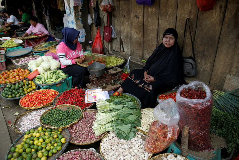 © Reuters. FILE PHOTO: A vegetable seller sits while waiting for customers at the morning market in Jakarta, Indonesia