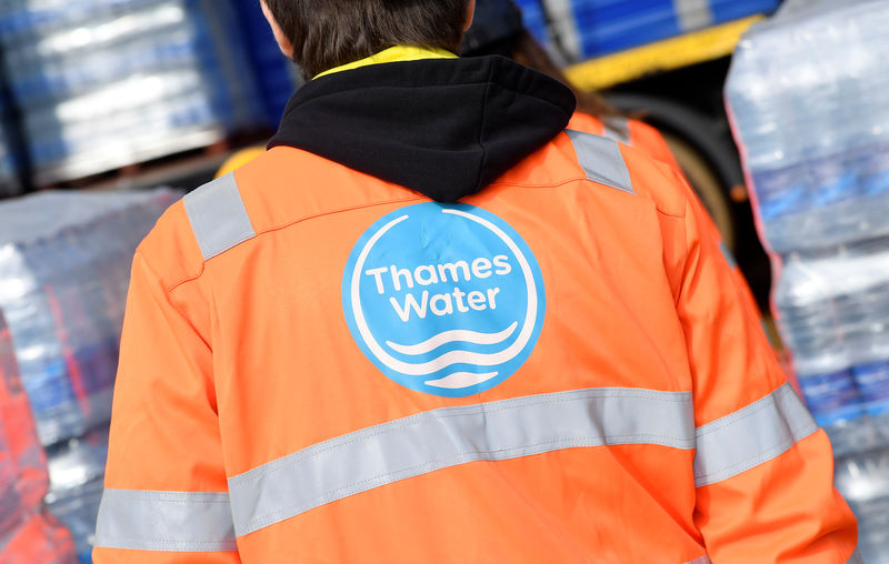 © Reuters. FILE PHOTO -  A Thames Water operative views pallets of bottled water for distribution in Hampstead in London, Britain