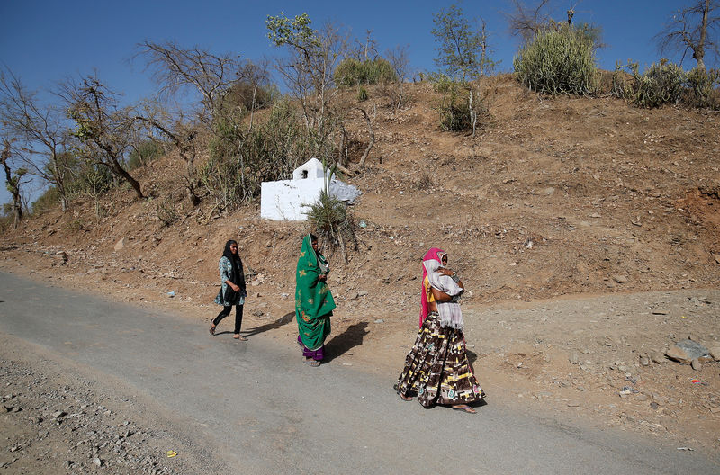 © Reuters. Women walk toward a polling station to cast their vote at Sirohi