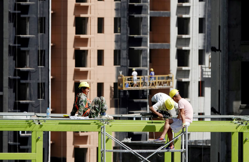 © Reuters. FILE PHOTO: Workers are seen at a construction site of residential buildings in Zhengzhou