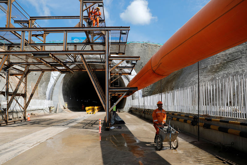 © Reuters. A worker pushes a wheelbarrow at Walini tunnel construction site for Jakarta-Bandung High Speed Railway in West Bandung regency