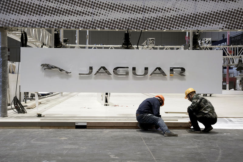 © Reuters. Workers set up a Jaguar booth inside the National Exhibition and Convention Center, the venue for the upcoming China International Import Expo, in Shanghai