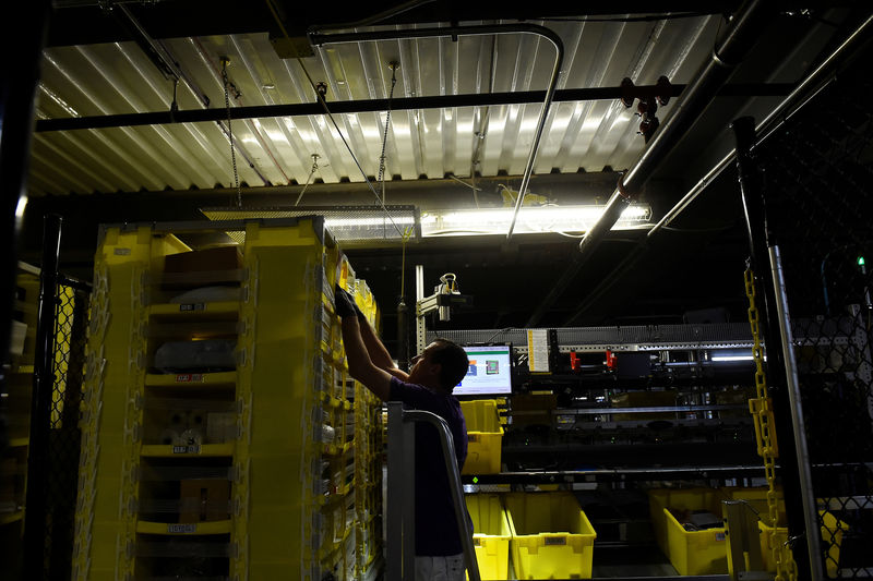 © Reuters. Worker takes products for delivery from a robotic shelf at the Amazon fulfilment center in Baltimore