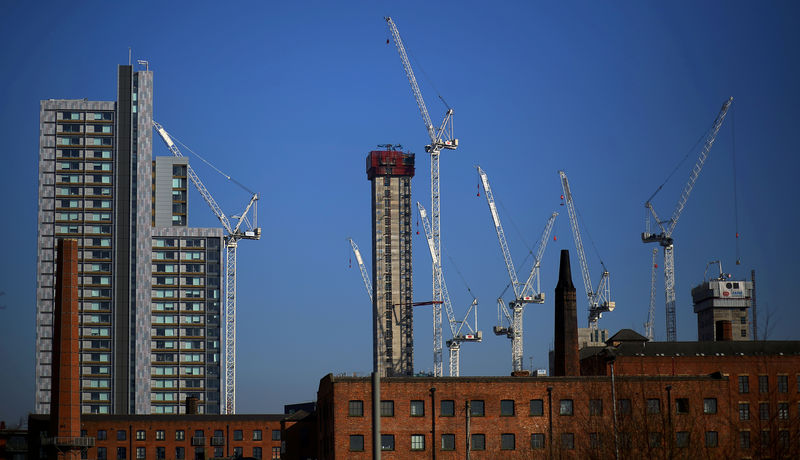 © Reuters. FILE PHOTO: Construction cranes are seen above a refurbished Mill building in the city centre of Manchester
