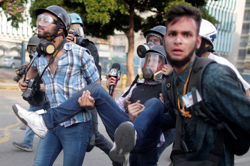 © Reuters. ATENCIÓN, IMÁGENES DE HERIDOS O MUERTOS. Un reportero herido, al centro, es cargado por sus compañeros de profesión durante protestas contra el gobierno de Nicolas Maduro, en Caracas.