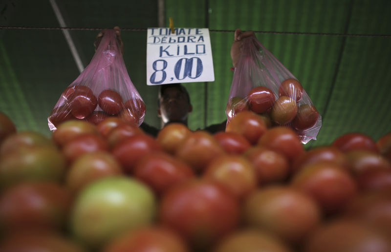 © Reuters. Vendedor segura sacolas de tomate em feira de São Paulo