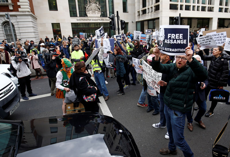 © Reuters. Demonstrator block traffic as they protest outside of Westminster Magistrates Court, where Wikileaks founder Julian Assange had a U.S. extradition request hearing, in London