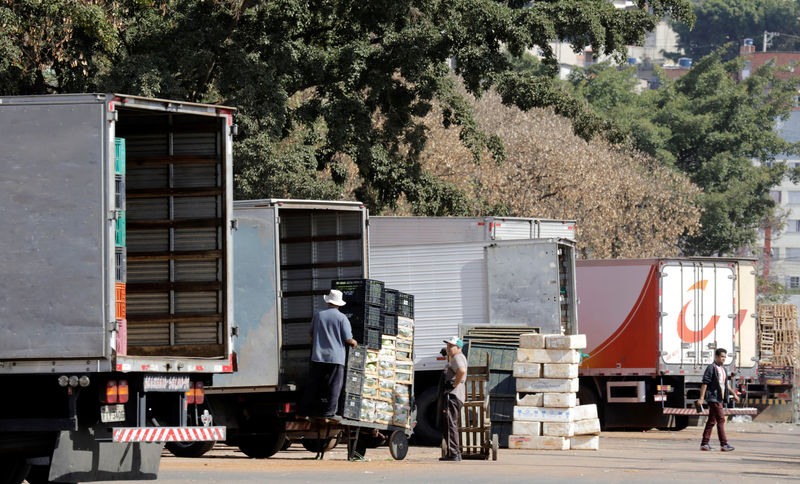 © Reuters. Funcionário descarregam caixas com vegetais de caminhões em São Paulo