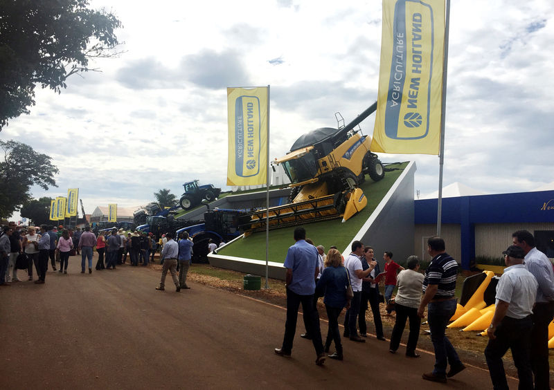 © Reuters. Visitors walk past one of the showrooms at the Agrishow farm equipment fair in Ribeirao Preto