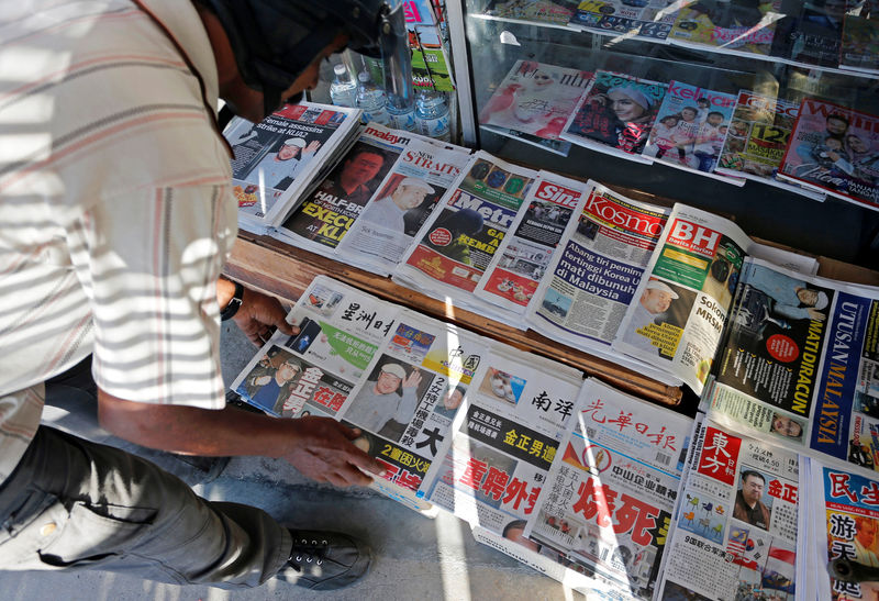 © Reuters. A newspaper vendor arranges newspapers showing front pages with images of Kim Jong Nam, at a news-stand outside Kuala Lumpur