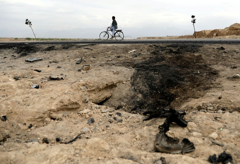 © Reuters. Homem passa de bicicleta por local de explosão de carro-bomba no Afeganistão