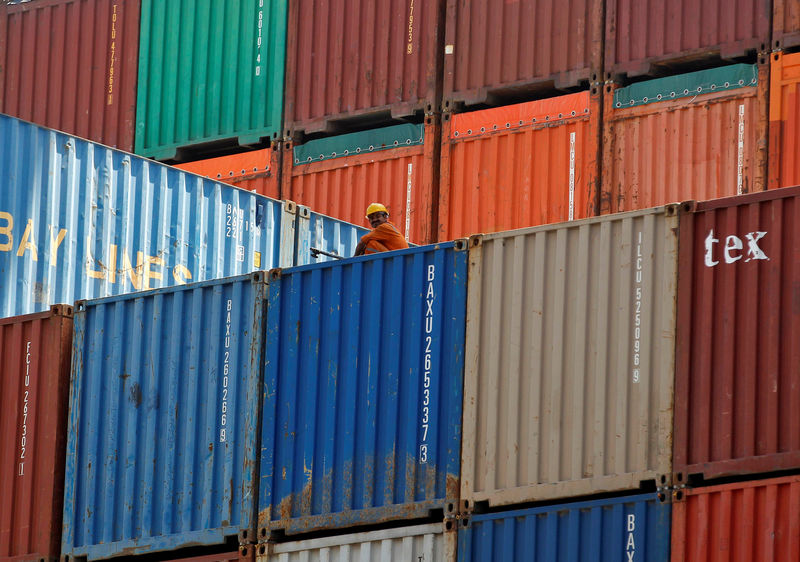 © Reuters. FILE PHOTO - A worker sits on a ship carrying containers at Mundra Port in the western Indian state of Gujarat