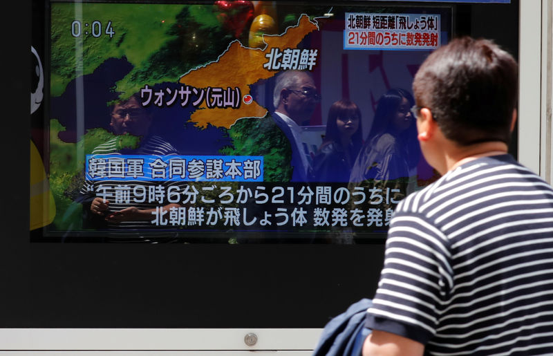 © Reuters. Un hombre mira un televisor en el que se informa de los disparos de proyectiles de Corea del Norte, en Tokio.